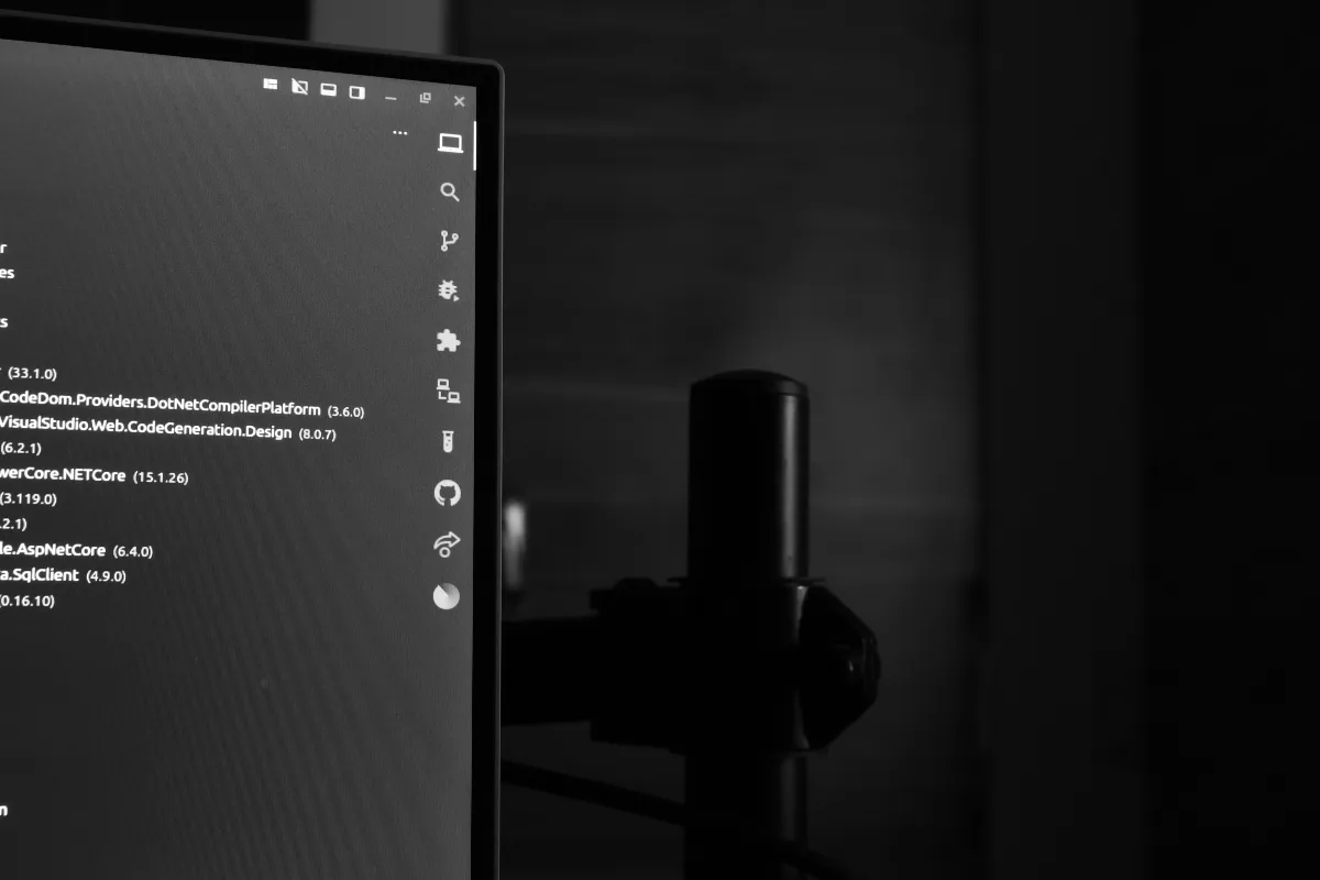 Computer monitor displaying code in a dark room.